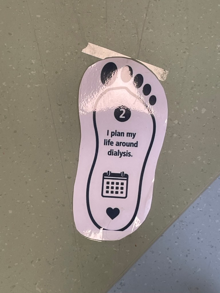 Footprint-shaped sign stating, “I plan my life around dialysis.”
